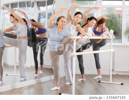 Group of women stretching at ballet barre Group of women stretching at ballet barre 135697105
