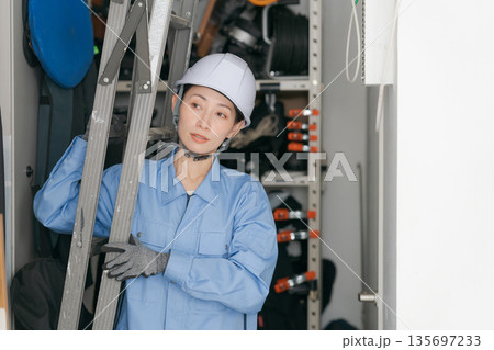 脚立を運ぶ女性作業員 135697233