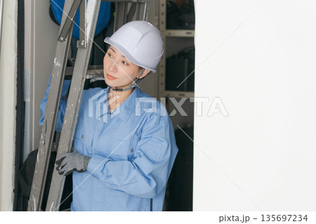 脚立を運ぶ女性作業員 135697234