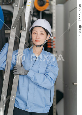 脚立を運ぶ女性作業員 135697236