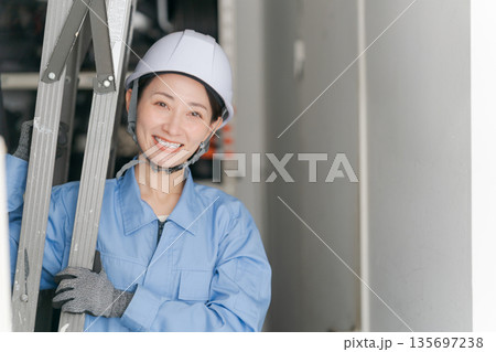 脚立を運ぶ女性作業員 135697238