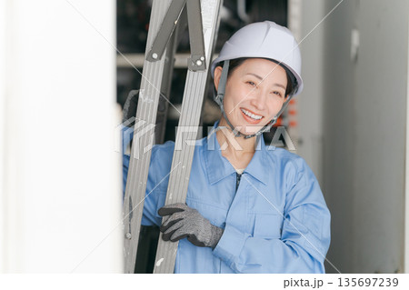 脚立を運ぶ女性作業員 135697239