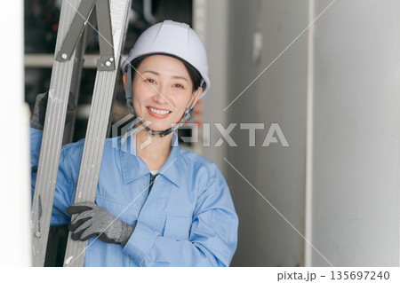 脚立を運ぶ女性作業員 135697240