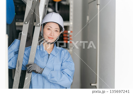脚立を運ぶ女性作業員 135697241
