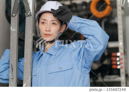 脚立を運ぶ女性作業員 脚立を運ぶ女性作業員 135697249