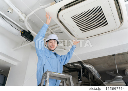 エアコンの点検をする女性作業員 135697764
