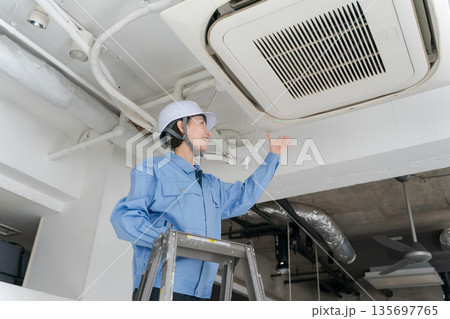 エアコンの点検をする女性作業員 エアコンの点検をする女性作業員 135697765