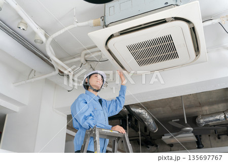 エアコンの点検をする女性作業員 135697767