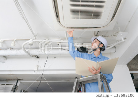 エアコンの点検をする女性作業員 135698100