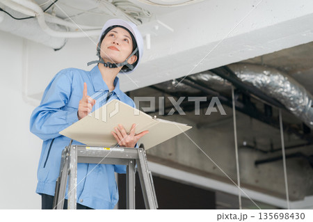 エアコンの点検をする女性作業員 エアコンの点検をする女性作業員 135698430