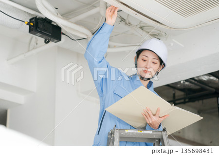 エアコンの点検をする女性作業員 135698431