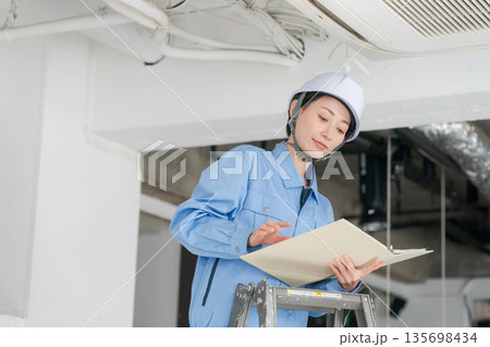 エアコンの点検をする女性作業員 135698434