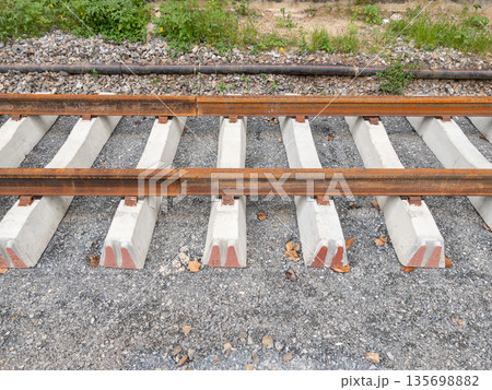 New railway tracks under construction on concrete sleepers. New railway tracks under construction on concrete sleepers. 135698882