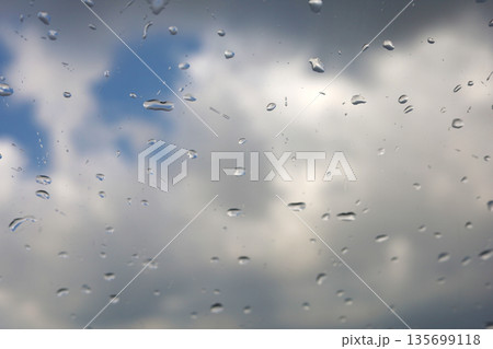Raindrops On Window With Cloudy Sky Raindrops On Window With Cloudy Sky 135699118