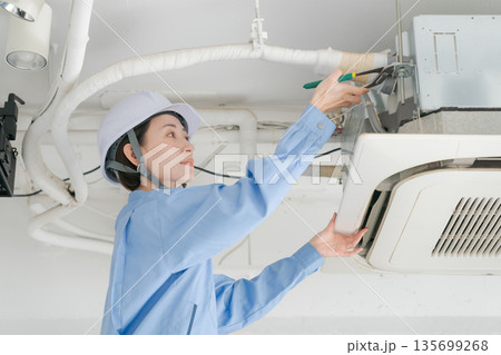 エアコンの点検をする女性作業員 エアコンの点検をする女性作業員 135699268