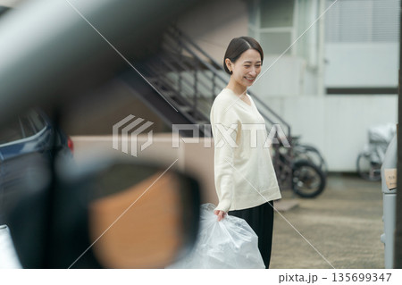 ゴミ捨てをする女性 135699347