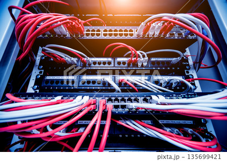 Network switch and ethernet cables in red and white colors. Data Center 135699421