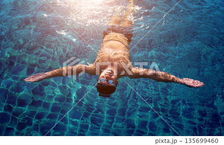 Young athletic man swimming in the swimming pool 135699460