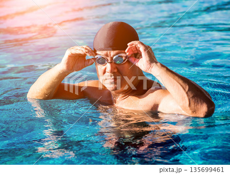 Young athletic man swimming in the swimming pool 135699461