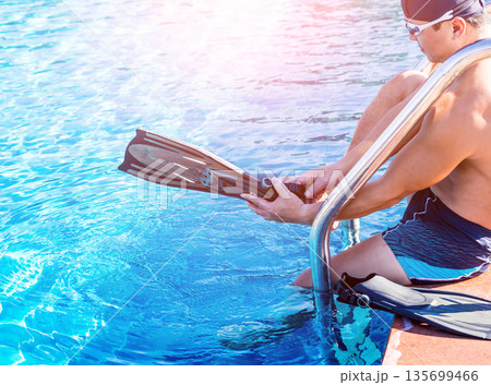 Young athletic man wearing flippers by the pool 135699466