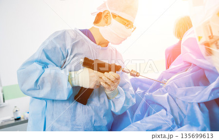 Arthroscope surgery. Orthopedic surgeons in teamwork in the operating room 135699613