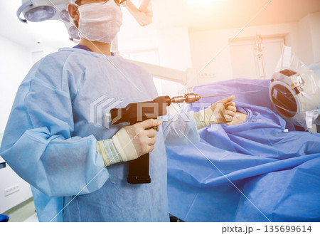 Arthroscope surgery. Orthopedic surgeons in teamwork in the operating room Arthroscope surgery. Orthopedic surgeons in teamwork in the operating room 135699614