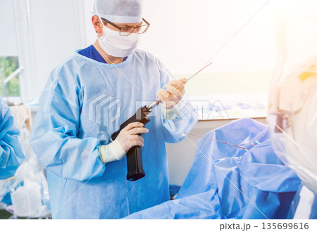 Arthroscope surgery. Orthopedic surgeons in teamwork in the operating room Arthroscope surgery. Orthopedic surgeons in teamwork in the operating room 135699616
