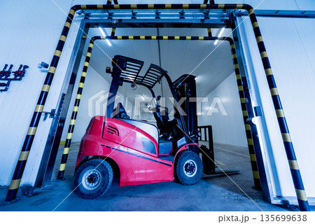 Forklift in a large industrial freezer warehouse. Empty warehouse Forklift in a large industrial freezer warehouse. Empty warehouse 135699638