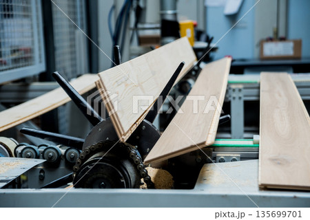 Production line of the wooden floor factory. CNC automatic woodworking machine. Production line of the wooden floor factory. CNC automatic woodworking machine. 135699701