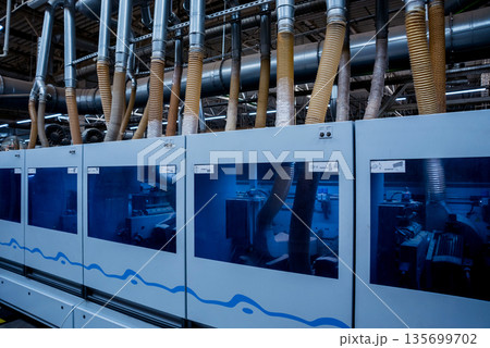 Production line of the wooden floor factory. CNC automatic woodworking machine. Production line of the wooden floor factory. CNC automatic woodworking machine. 135699702