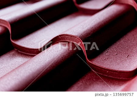 Red metallic roof tiles background with drops of water. Red metallic roof tiles background with drops of water. 135699757
