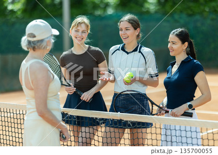 Tennis match female participants chat after game Tennis match female participants chat after game 135700055