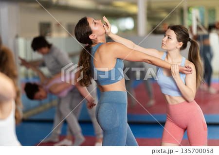 Women practice self-defense techniques in pairs Women practice self-defense techniques in pairs 135700058