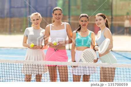 Team of female padel tennis players on court Team of female padel tennis players on court 135700059