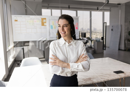 Latina businesswoman posing in modern conference room 135700078