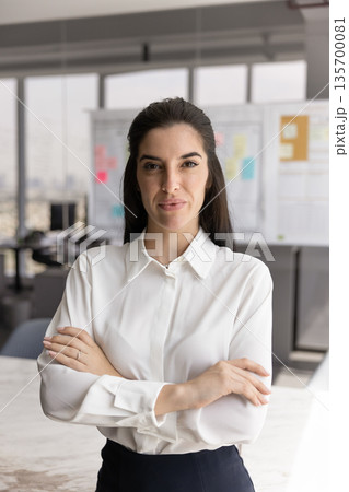 Professional businesswoman standing confidently in modern office 135700081