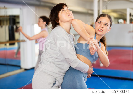 Women practice self-defense techniques in pairs 135700376