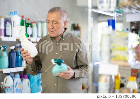 European man choosing spray in supermarket 135700390