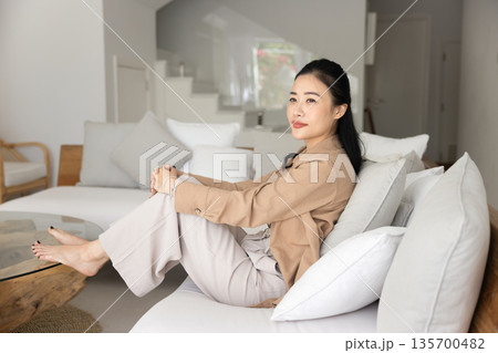 Pensive Vietnamese woman dressed in casual clothes relaxing at home 135700482