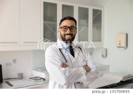 Happy confident handsome healthcare professional man posing for clinic profile Happy confident handsome healthcare professional man posing for clinic profile 135700693