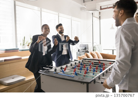 Overjoyed excited corporate employees table football players laugh celebrate success Overjoyed excited corporate employees table football players laugh celebrate success 135700767