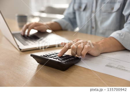 Close up cropped shot businessman hands using notebook and calculator 135700942