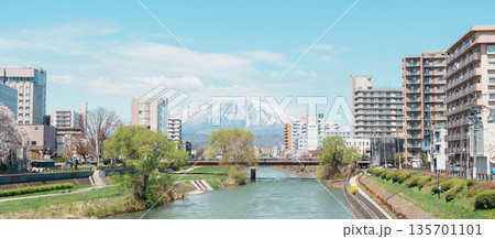 Beautiful Iwate mountain and Kitakami river with flowers blooming in Spring season, cityscape against blue sky in Morioka city, Iwate prefecture, Japan. Iwate, Japan, 24 April 2025 Beautiful Iwate mountain and Kitakami river with flowers blooming in Spring season, cityscape against blue sky in Morioka city, Iwate prefecture, Japan. Iwate, Japan, 24 April 2025 135701101