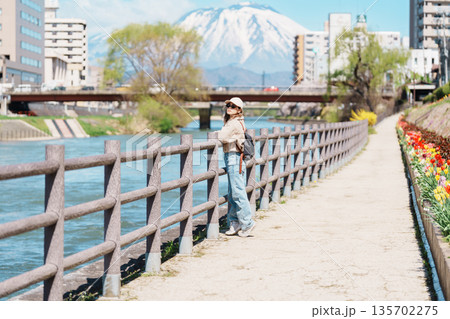 Woman tourist sightseeing Iwate mountain and Kitakami river with flowers in Spring, happy traveler travel in Morioka city, Iwate prefecture, Japan. famous Landmark Travel and Vacation destination 135702275