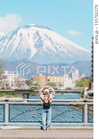 Woman tourist sightseeing Iwate mountain and Kitakami river with flowers in Spring, happy traveler travel in Morioka city, Iwate prefecture, Japan. famous Landmark Travel and Vacation destination 135702278