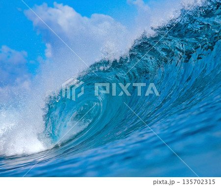 Blue wave breaking on a beach in sea Blue wave breaking on a beach in sea 135702315
