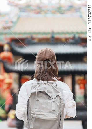 Woman traveling in Wat Mangkorn Kammalawas, Leng Nuei Yee as Chinese temple. Asian traveler visiting at Yaowarat road or Chinatown of Bangkok, landmark and popular for tourist attractions in Thailand 135702711