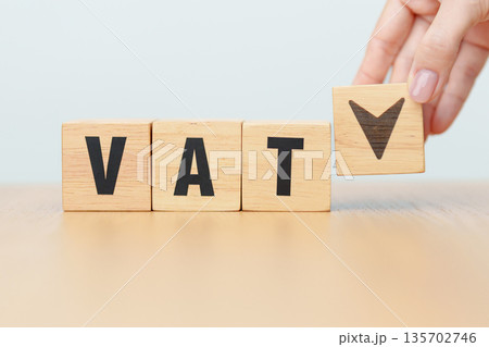 hand change wooden block with VAT text to UP and Down arrow icon. Value Added Tax, decrease and Increase, Taxpayer, Taxable Income, Tax Filing, Deduction, Withholding Tax,  Computation and Exemption 135702746