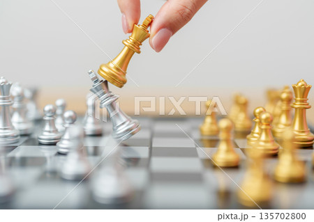 hand moving gold Chess King figure and Checkmate opponent during chessboard competition. Strategy, Success, management, business planning, win, disruption, Trade war and leadership concept hand moving gold Chess King figure and Checkmate opponent during chessboard competition. Strategy, Success, management, business planning, win, disruption, Trade war and leadership concept 135702800