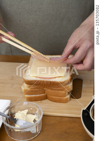 ホットサンドメーカーでホットサンドを作る手元 ホットサンドメーカーでホットサンドを作る手元 135703082